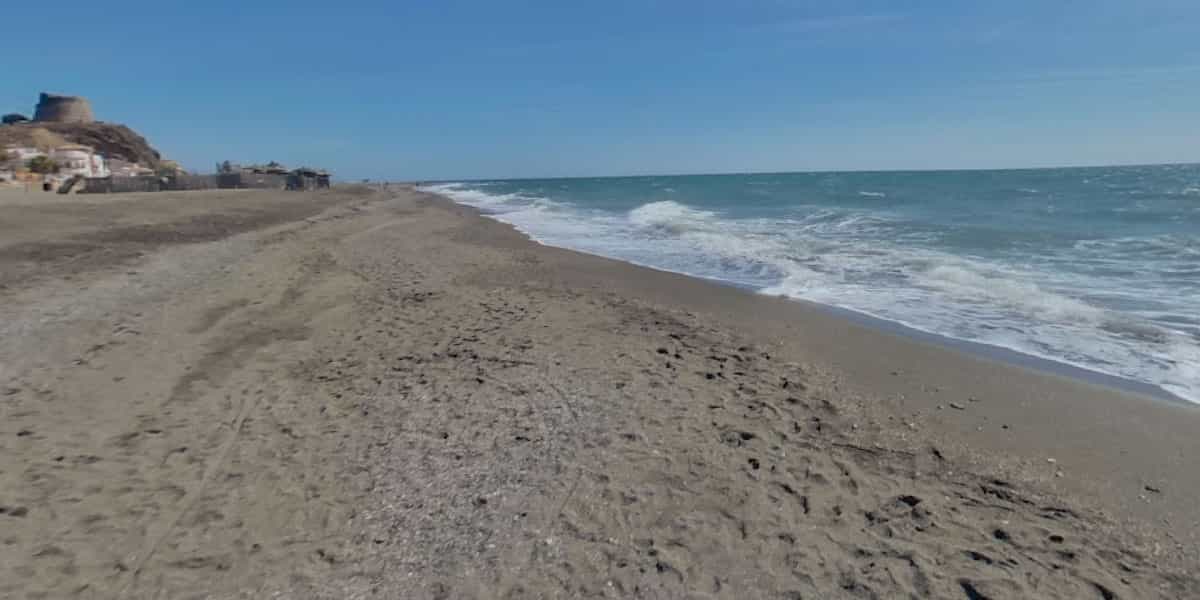 Playa de Benajarafe met donker zand, promenade en rustige sfeer