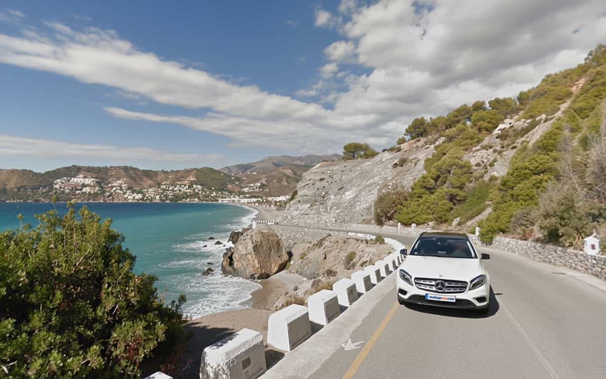 Voiture roulant sur la route côtière de La Herradura avec vue sur la mer